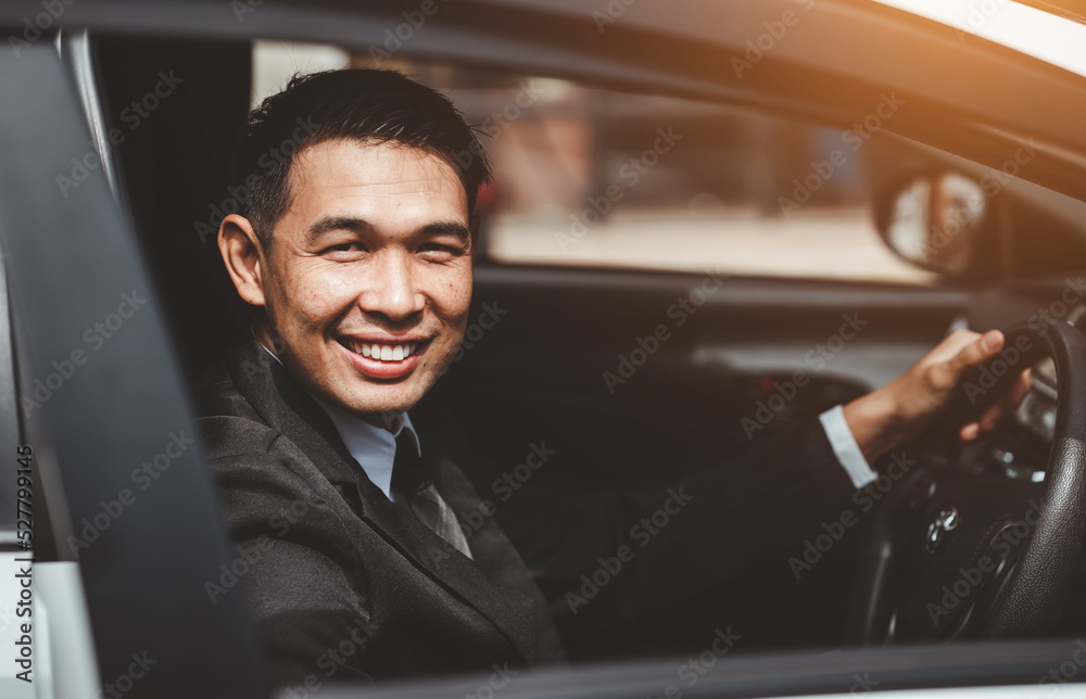 Happy young Asian businessman driving a car. Happy young Asian businessman driving a car.