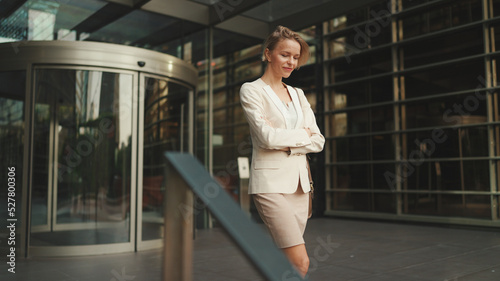 Businesswoman with blond hair wearing beige suit leaving business center