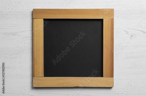 Blank chalkboard on white wooden background, top view. Space for text