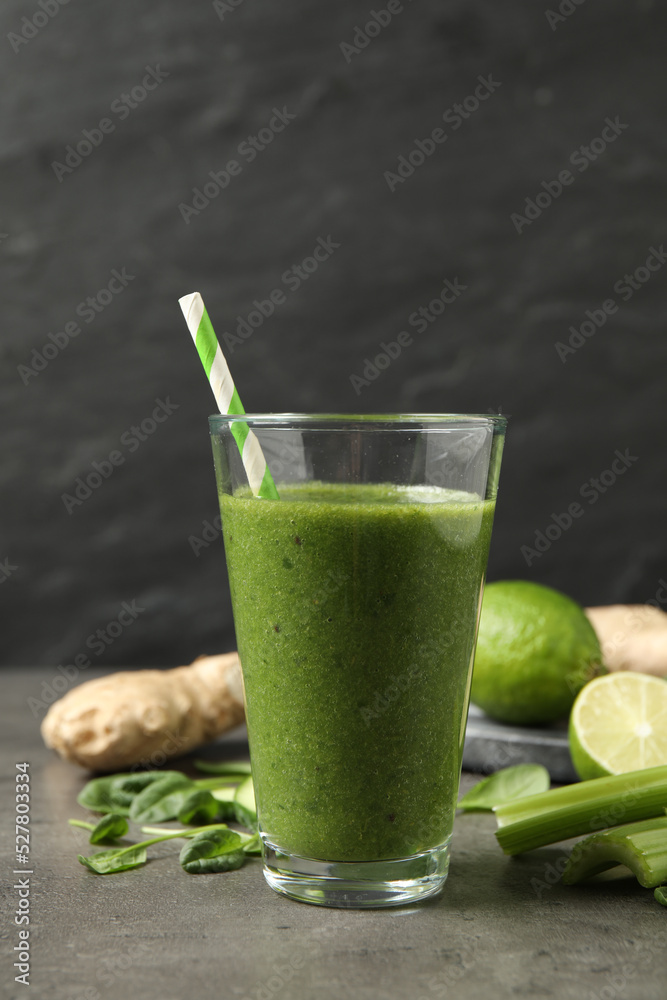 Green juice and fresh ingredients on grey table Green juice and fresh ingredients on grey table