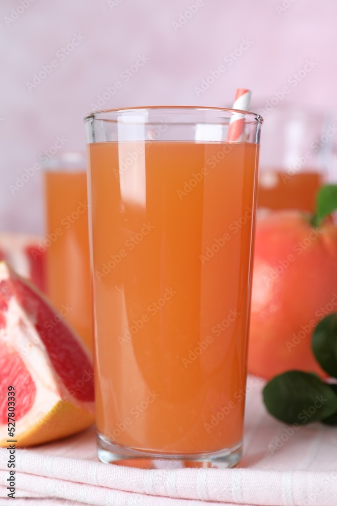 Tasty freshly made grapefruit juice on towel, closeup