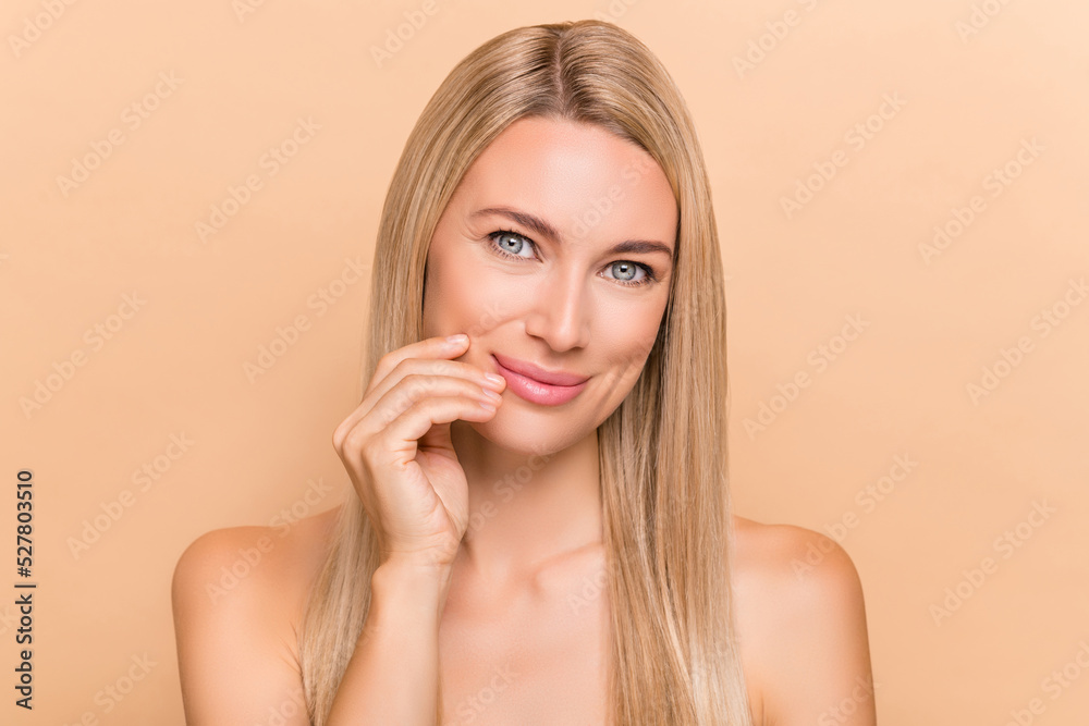 Portrait of attractive cheery nude woman touching pure smooth skin cc cream tonic isolated over beige pastel color background Portrait of attractive cheery nude woman touching pure smooth skin cc cream tonic isolated over beige pastel color background