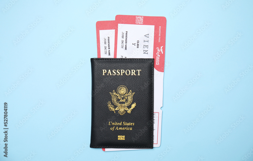 United States passport with tickets on light blue background, top view