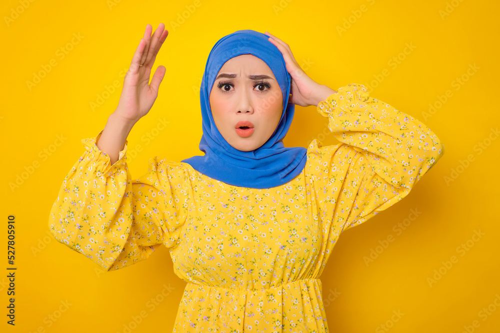 Shocked young Asian woman in casual dress looking at camera with opened mouth, reacting to news isolated on yellow background Shocked young Asian woman in casual dress looking at camera with opened mouth, reacting to news isolated on yellow background
