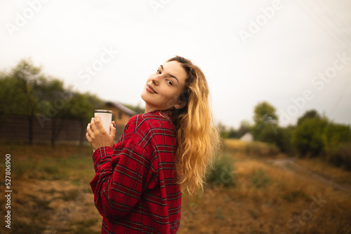A girl with a thermos in her hands enjoys autumn. Autumn mood. The arrival of autumn. A walk through the autumn forest.