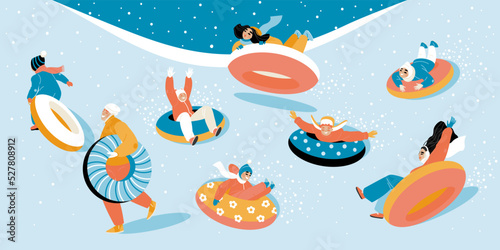 Children on a snow tubing slide down a hillside during a snowfall. Happy kids actively spend time on winter holidays.