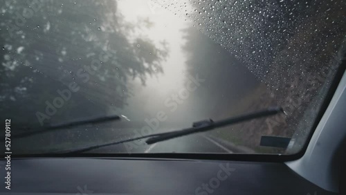 Handheld cinematic shot from the car's cabin. Driving in the rain on a winding mountain road. photo