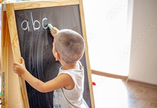 A child writes on a blackboard