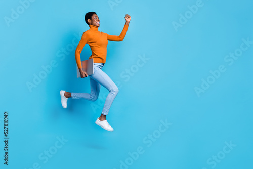Full size profile side photo of cheerful trans nonbinary businesswoman running to close deadline isolated on blue color background