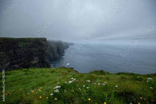 Fotografia vue sur les falaises de Moher en Irlande qui surplombent la mer par temps gris e