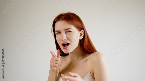 Red-haired young woman, expressing the emotion of surprise or suspicion.