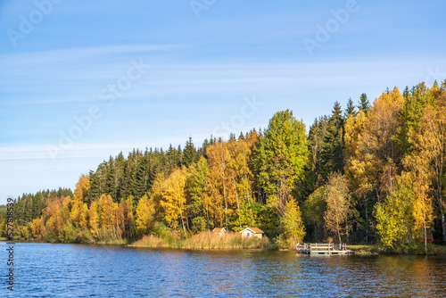 Cottage with a jetty by a lake at autumn