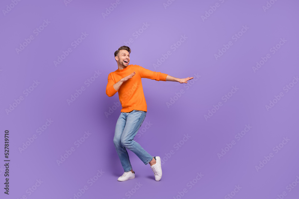 Full body photo of attractive overjoyed man hear his favorite song start dancing isolated on violet color background