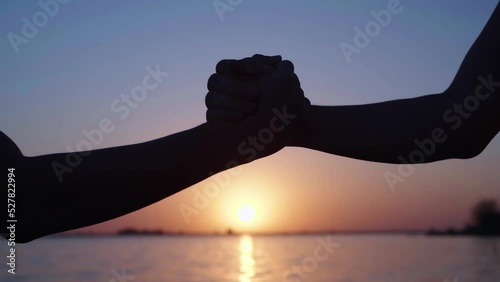 handshake at sunset against the background of the sea