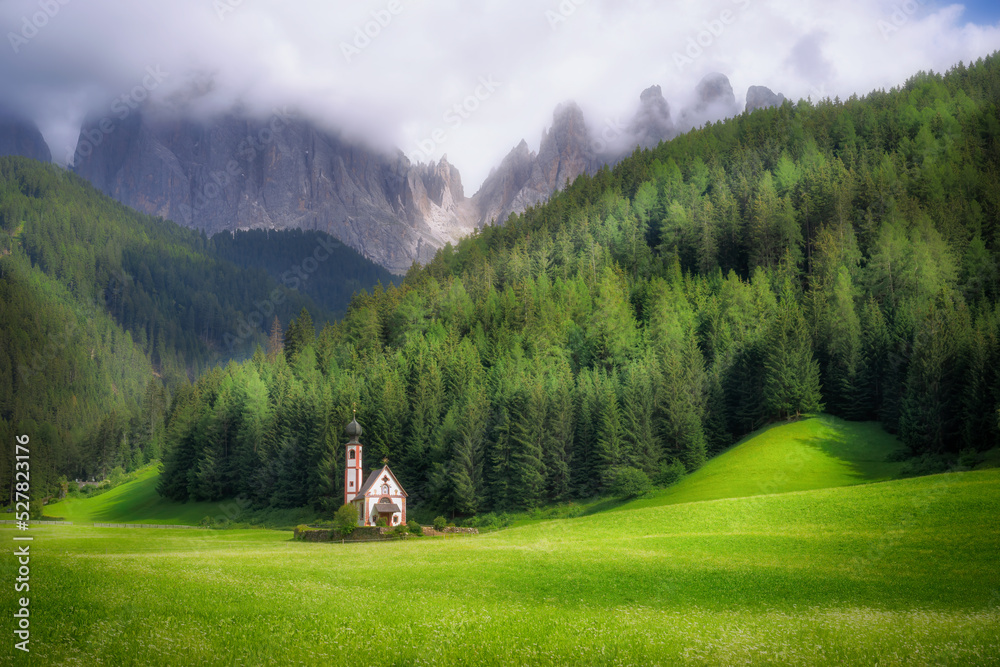 Beautiful view of The Johannes chapel (St. Johann church) with Dolomite mountains behind at Funes in South Tyrol in Italy in summer time.