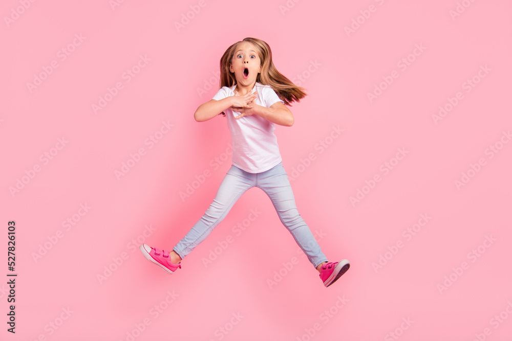 Full length portrait of impressed active girl jumping open mouth unbelievable isolated on pink color background Full length portrait of impressed active girl jumping open mouth unbelievable isolated on pink color background