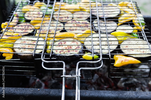 Vegetables on barbecue grill, close-up. Peppers and eggplants on an iron grate