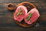 Steaks. Fresh Filet mignon Steaks with spices rosemary and pepper on black marble board on old wooden table background. Top view. Mock up.