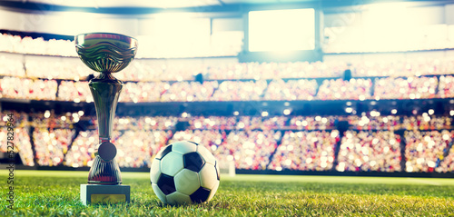 Football soccer ball and trophy cup on stadium #527829964