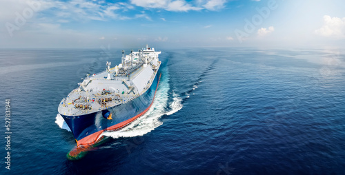 Front view of a big LNG tanker ship traveling with full speed over the calm, blue ocean as a concept for international fuel industry with copy space photo