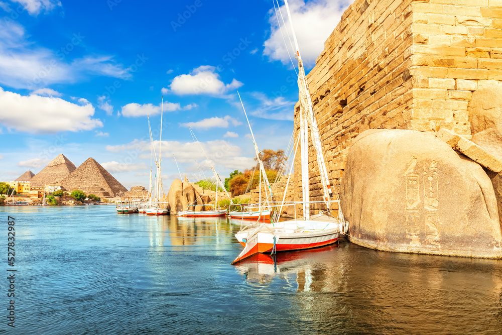 Sailboats near the ancient rocks on the bank of the Nile, Aswan, Egypt
