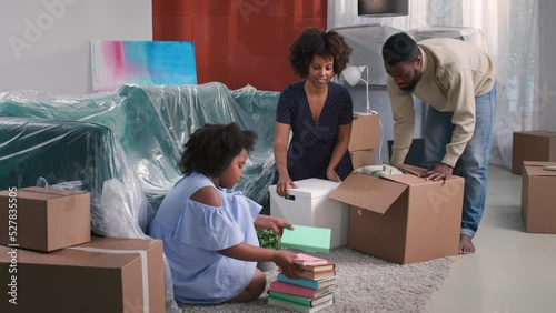 Happy african american young family pack stuff and move to new house.