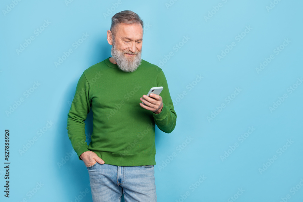 Photo of middle aged blogger read network news on device technology isolated blue color background Photo of middle aged blogger read network news on device technology isolated blue color background