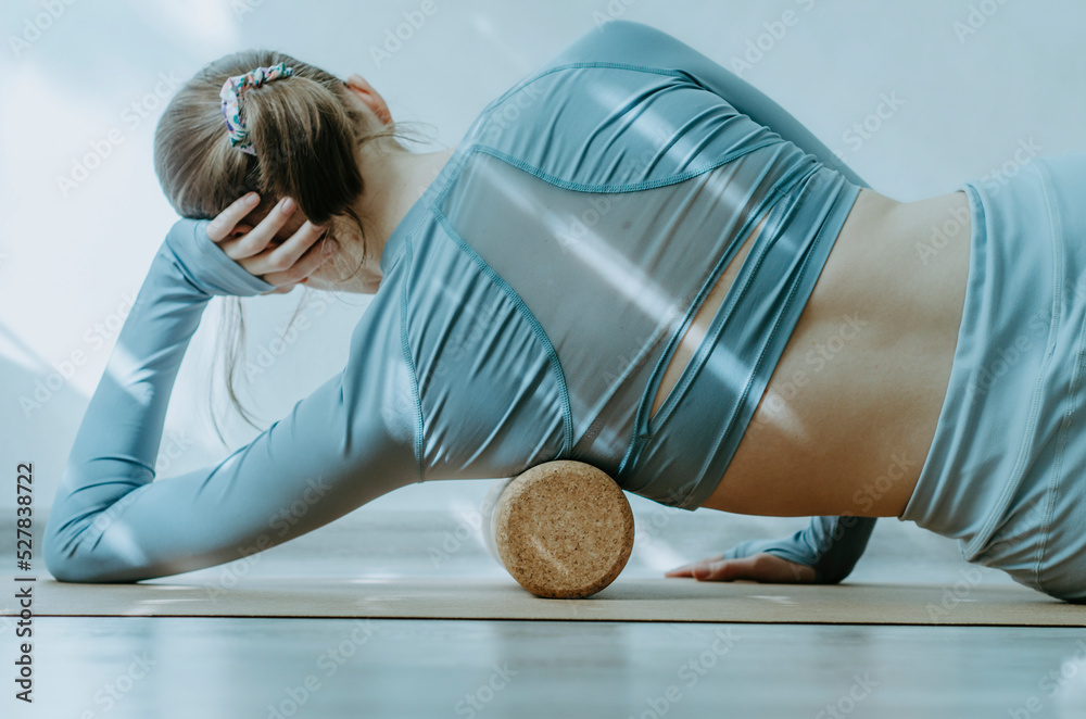 Woman rolling lower armpit muscles on cork roller Stock Photo Adobe Stock