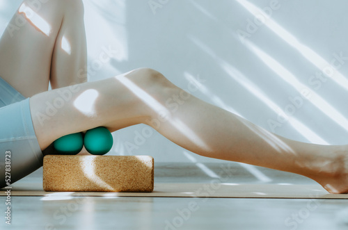 Fotografie, Tablou Person doing self myofascial release of hamstrings with two massage balls on cork block