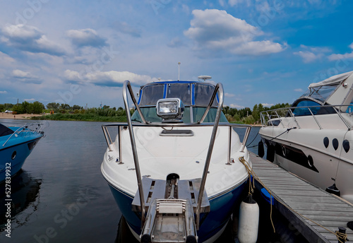 Boats moored to a pier in a yacht marina. Summer vacations and tourism