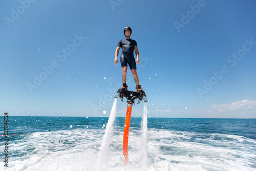 Water extreme sport. The guy is flying at the aquatic flyboard. A lot of water pressure photo