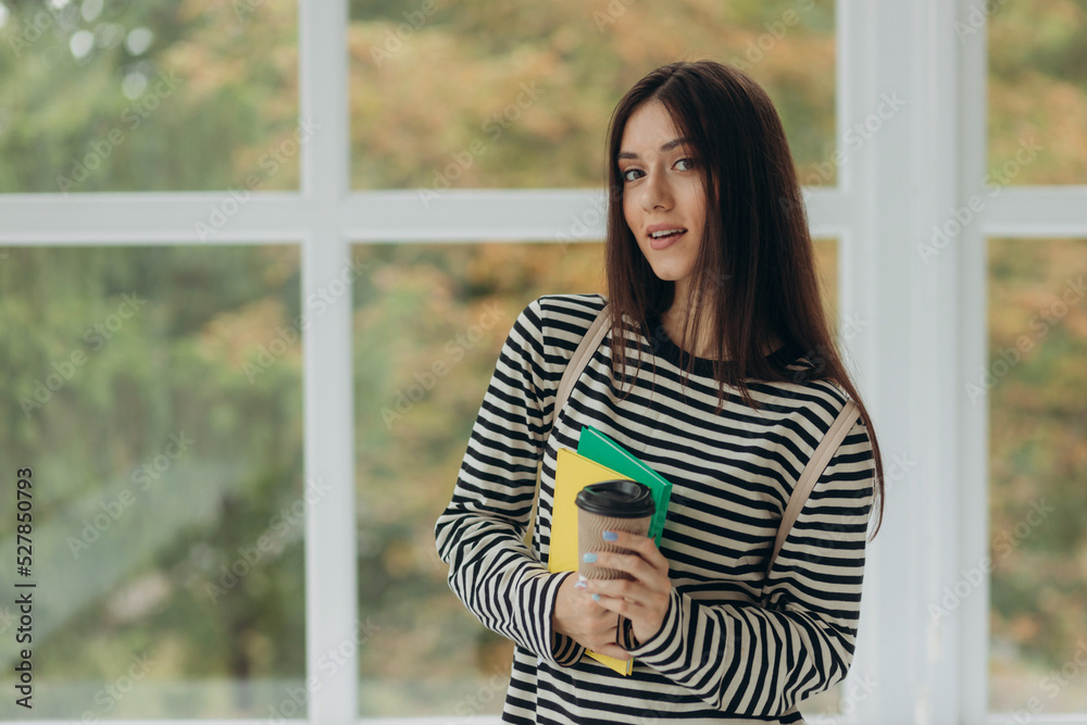 Portrait of a smiling student girl with notebooks and a backpack. The concept of school and college education Portrait of a smiling student girl with notebooks and a backpack. The concept of school and college education