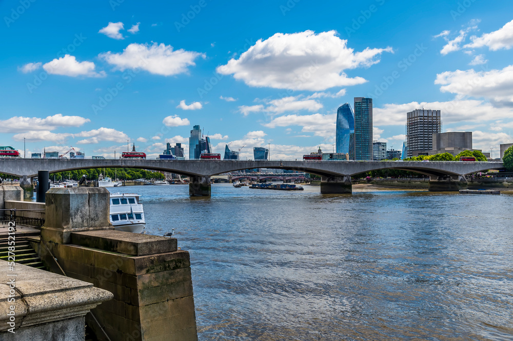 A view towards Waterloo bridge from the Embankment along the River Thames in London, UK in summertime