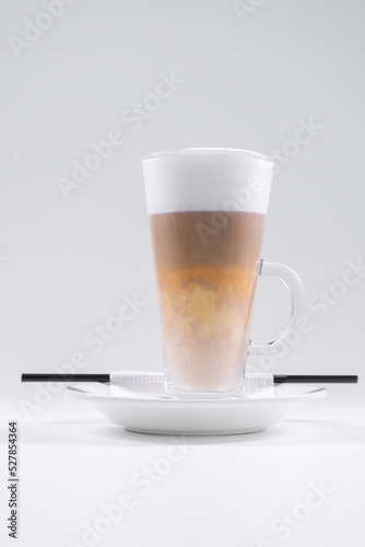 tasty italian latte coffee with straw and saucer isolated on white background