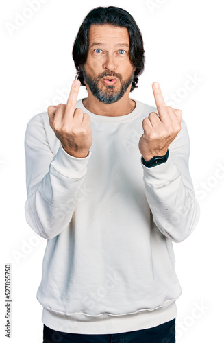 Middle age caucasian man wearing casual clothes showing middle finger doing fuck you bad expression, provocation and rude attitude. screaming excited