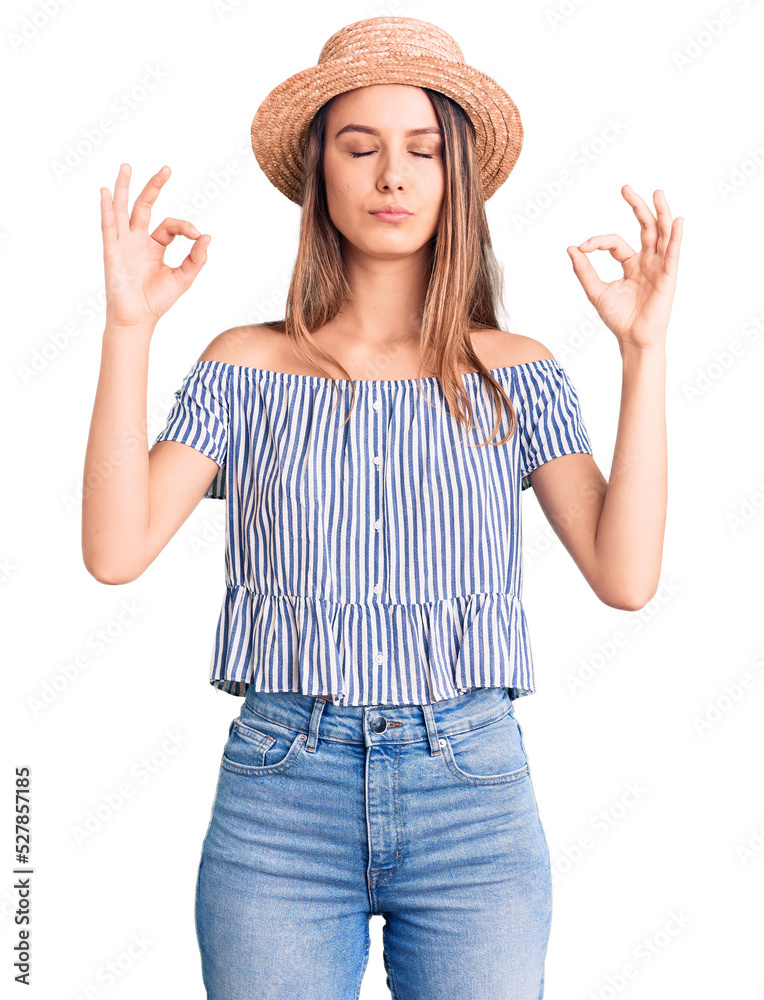 Young beautiful girl wearing hat and t shirt relax and smiling with eyes closed doing meditation gesture with fingers. yoga concept. Young beautiful girl wearing hat and t shirt relax and smiling with eyes closed doing meditation gesture with fingers. yoga concept.