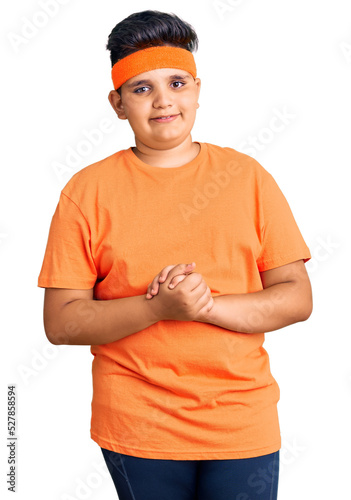 Little boy kid wearing sportswear with hands together and crossed fingers smiling relaxed and cheerful. success and optimistic