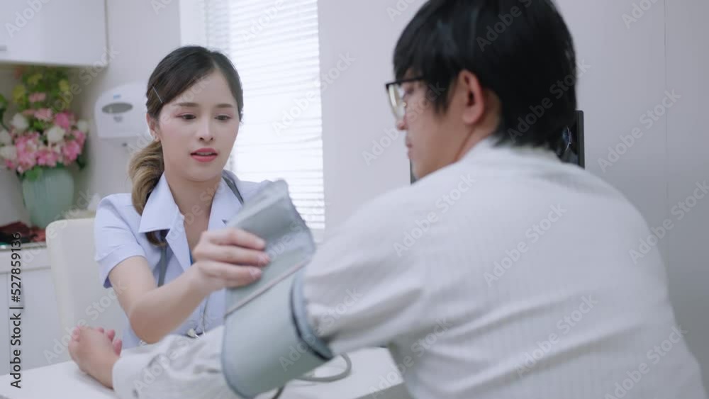 cardiology healthcare concept.Female doctor measuring high low blood pressure of asian male patient in hospital.Cardiologist examining man hypertensive sufferer using medical tonometer. cardiology healthcare concept.Female doctor measuring high low blood pressure of asian male patient in hospital.Cardiologist examining man hypertensive sufferer using medical tonometer.