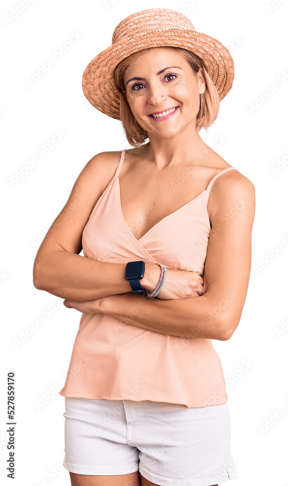 Young blonde woman wearing summer hat happy face smiling with crossed arms looking at the camera. positive person. Young blonde woman wearing summer hat happy face smiling with crossed arms looking at the camera. positive person.