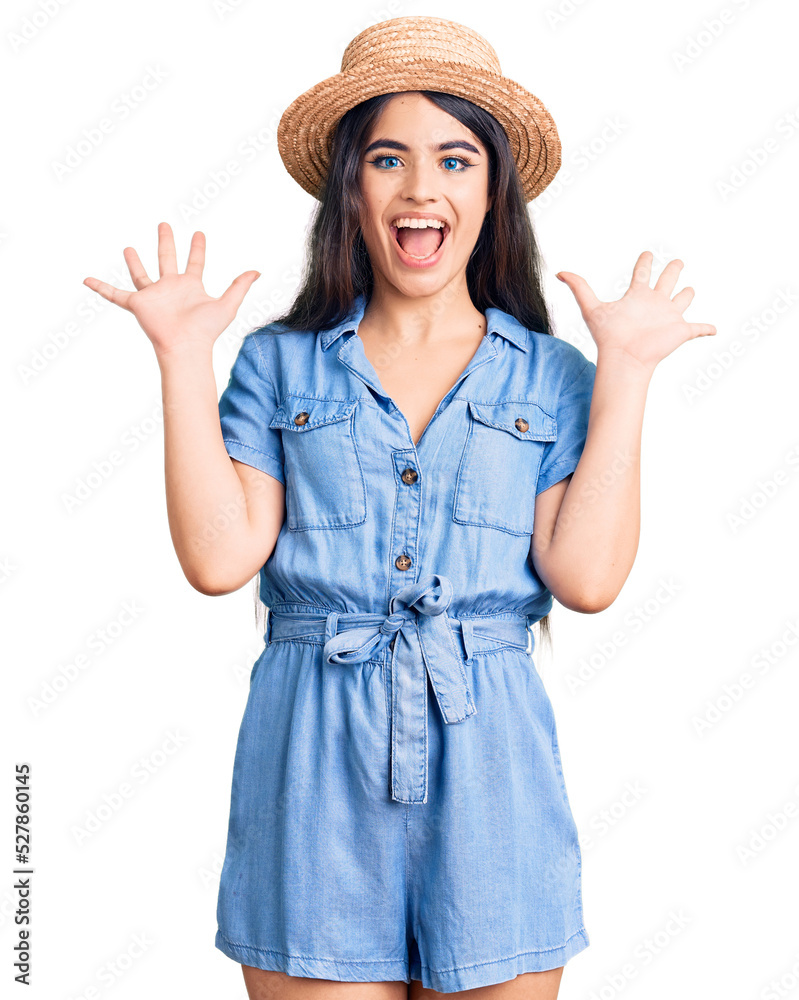 Brunette teenager girl wearing summer hat celebrating crazy and amazed for success with arms raised and open eyes screaming excited. winner concept Brunette teenager girl wearing summer hat celebrating crazy and amazed for success with arms raised and open eyes screaming excited. winner concept