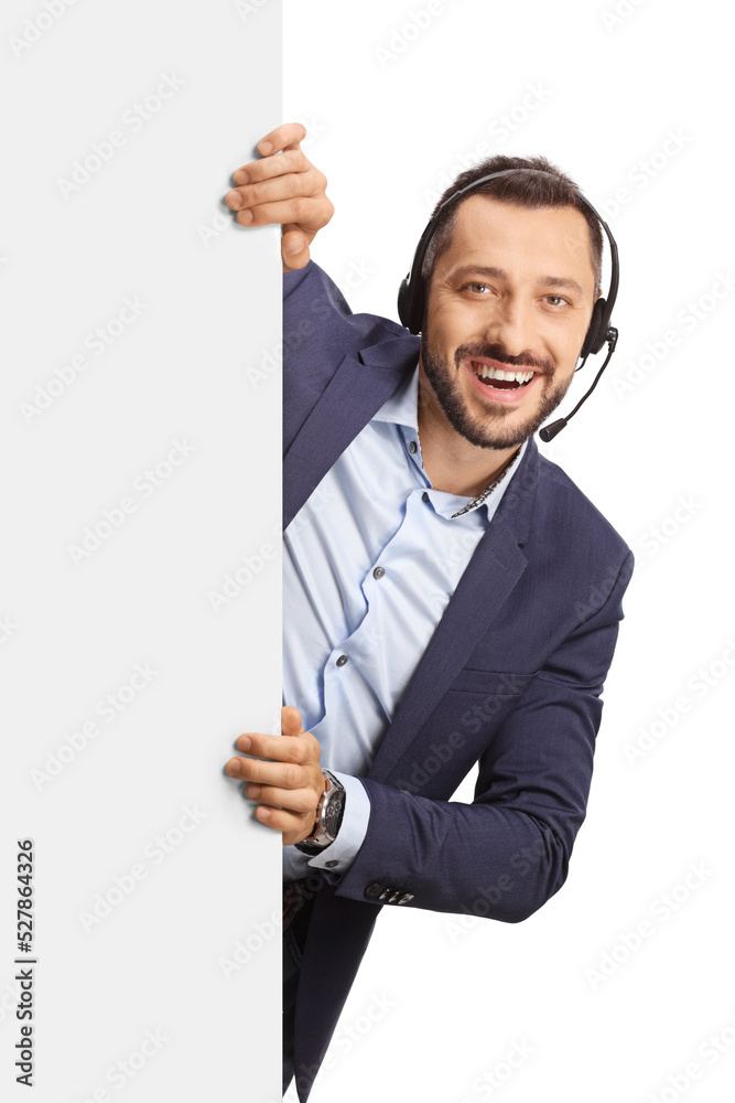 Professional man with a headset and hands free microphone standing behind a blank panel Professional man with a headset and hands free microphone standing behind a blank panel