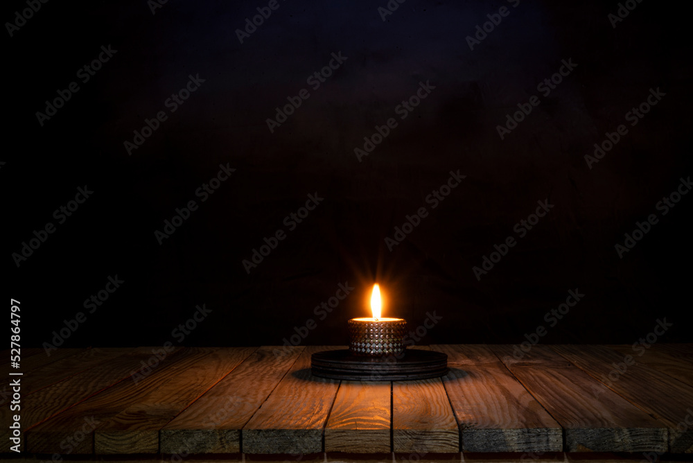 Candle light spreading on wooden table surface
