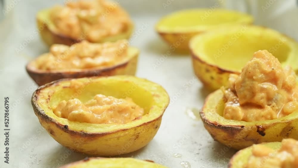 The cook fills the baked potatoes with a filling of vegetables, meat and sauce.
The cook fills the baked potatoes with a filling of vegetables, meat and sauce.