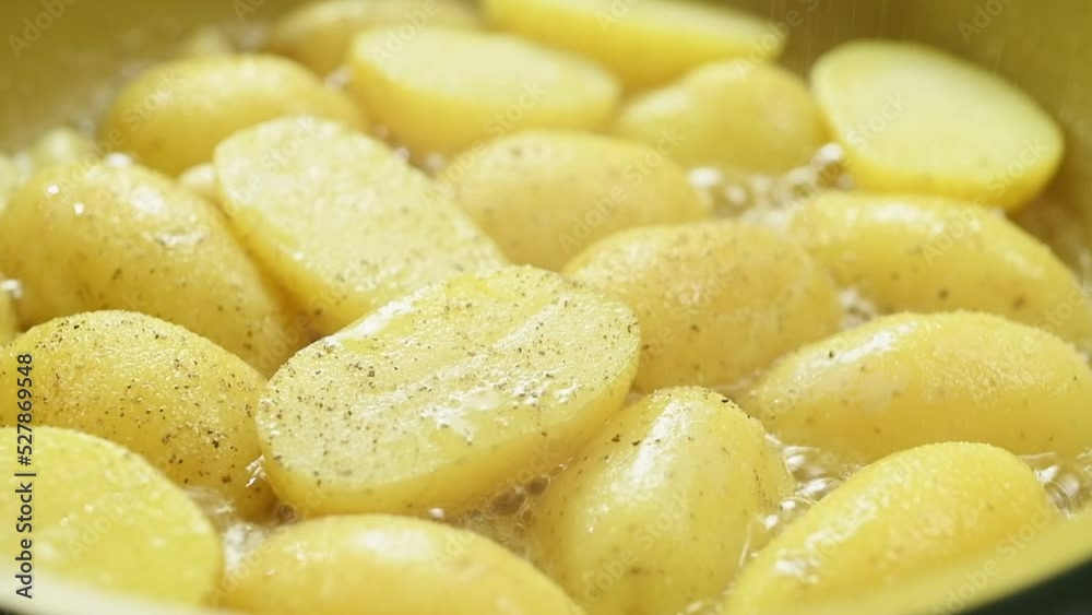 The cook sprinkles the chopped potatoes with black pepper while the potatoes are frying in the pan.
The cook sprinkles the chopped potatoes with black pepper while the potatoes are frying in the pan.