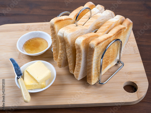 Breakfast toast in rack with butter and marmalade wooden table background photo