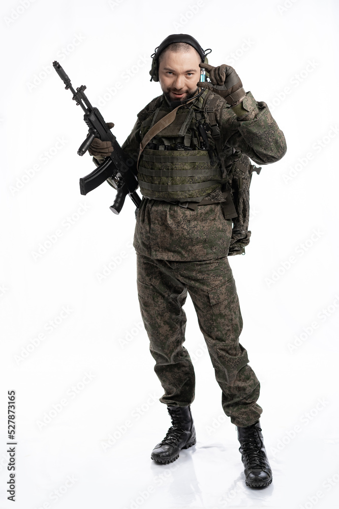 soldier in the studio on a white background. a man in military uniform with a rifle or machine gun. military or airball player