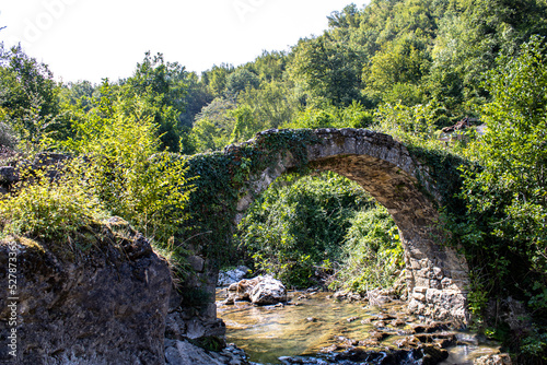 Ancient stone bridge with old destroyed arches