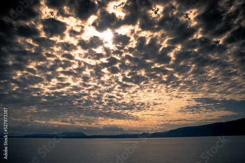 Sol tras las nubes que parecen algod  n sobre el lago Villarrrica