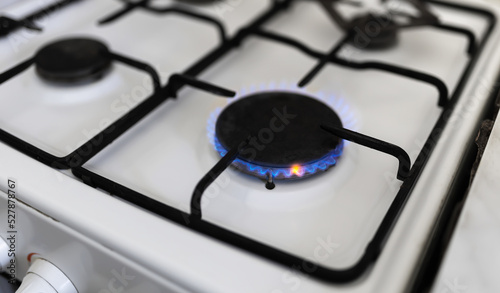 Old gas stove with blue flame. Saving energy, price concept.