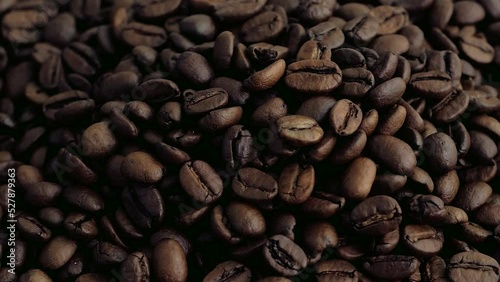 macro shot of an arabica coffee bean that is twirling the background is full of coffee beans photo